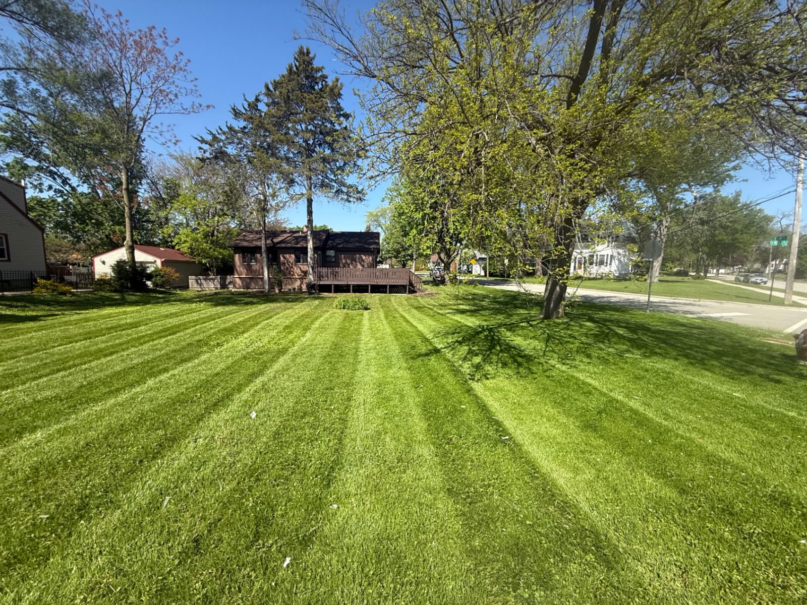 Corner-lot lawn freshly mowed in stripes