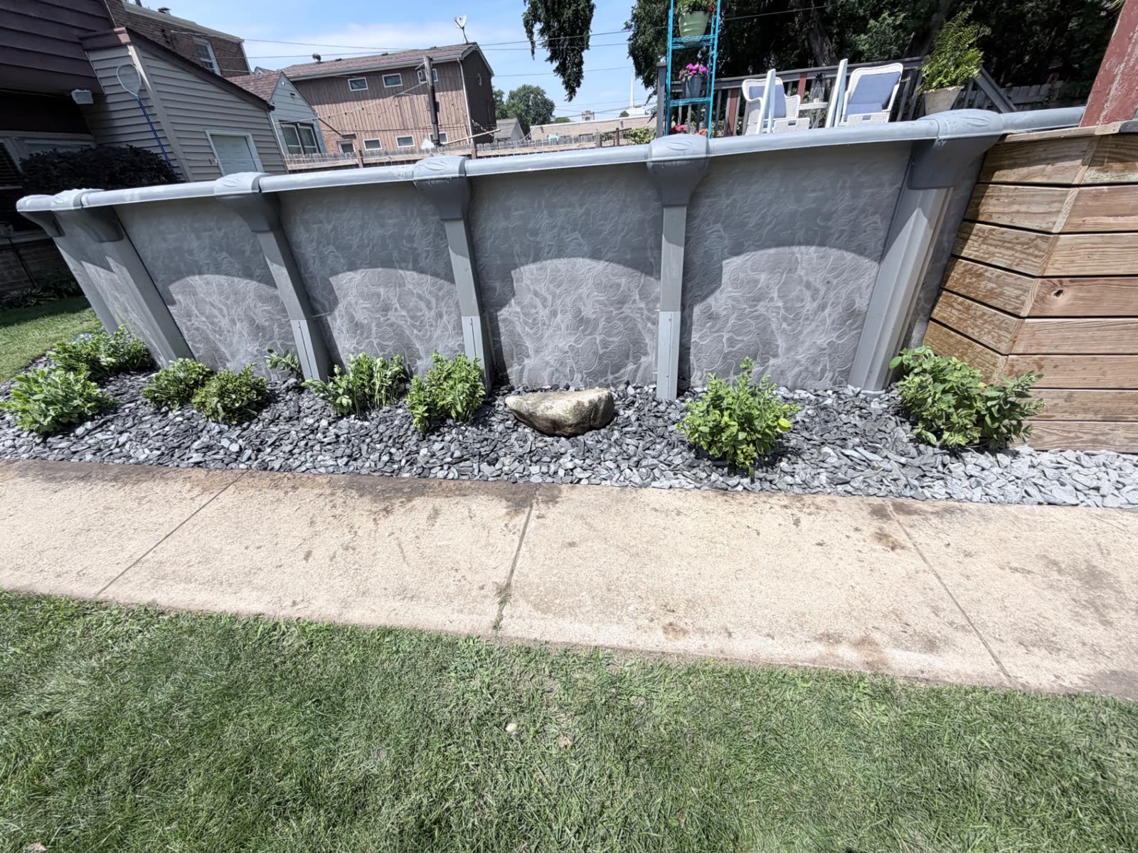 Curved rock bed with low plantings at a pool base