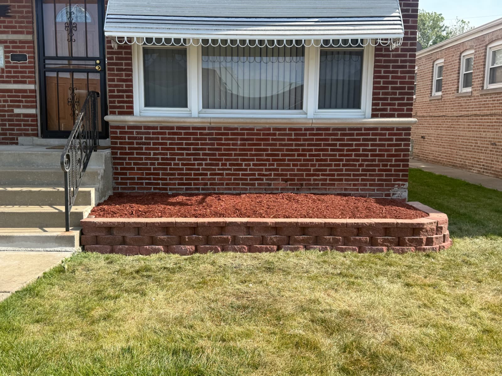Block retaining-wall bed filled with red mulch
