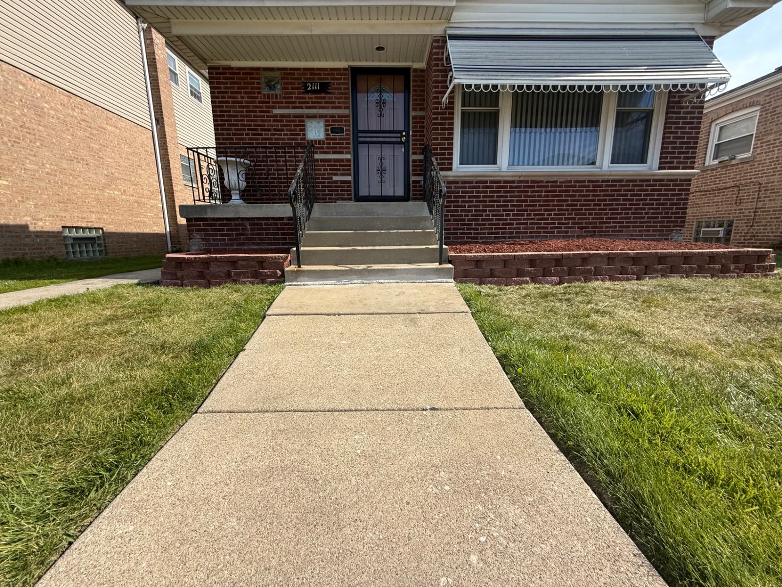 Front-porch retaining wall bed with red mulch