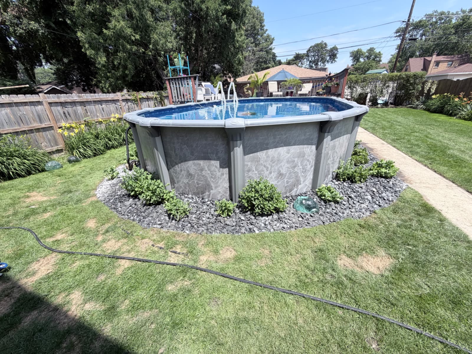 Pool-side rock bed next to a wooden deck