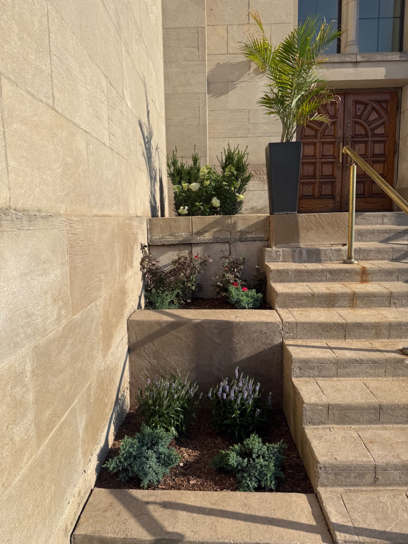 Tiered stone planting beds with fresh mulch